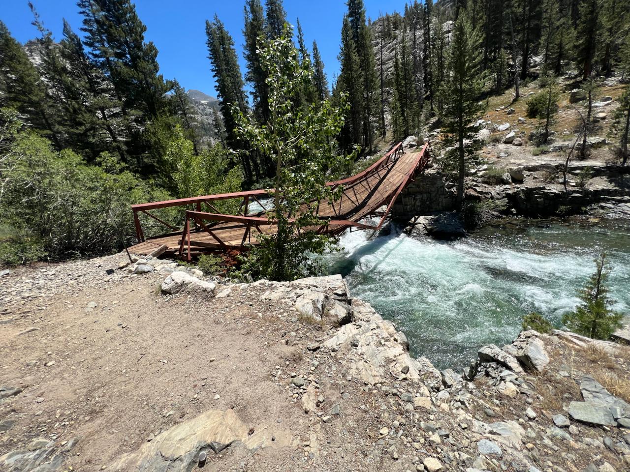 Collapsed PCT bridge over turquoise mountain river